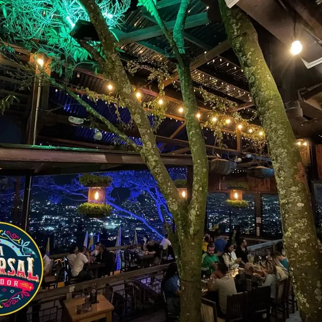 La terraza de La Sucursal al anochecer, con las luces de Medellín al fondo