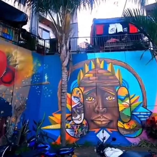 Mural de la Comuna 13 con un rostro de gran formato en colores vivos